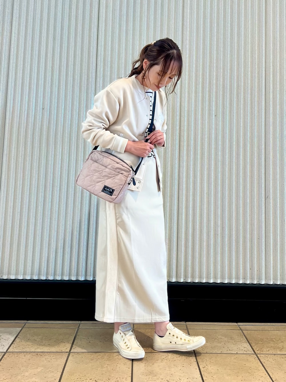 ホワイト系のスタジャン、ベージュ系のTシャツ/カットソー、ホワイト系のスカートを着用したレディースの秋コーディネートの2枚目の写真