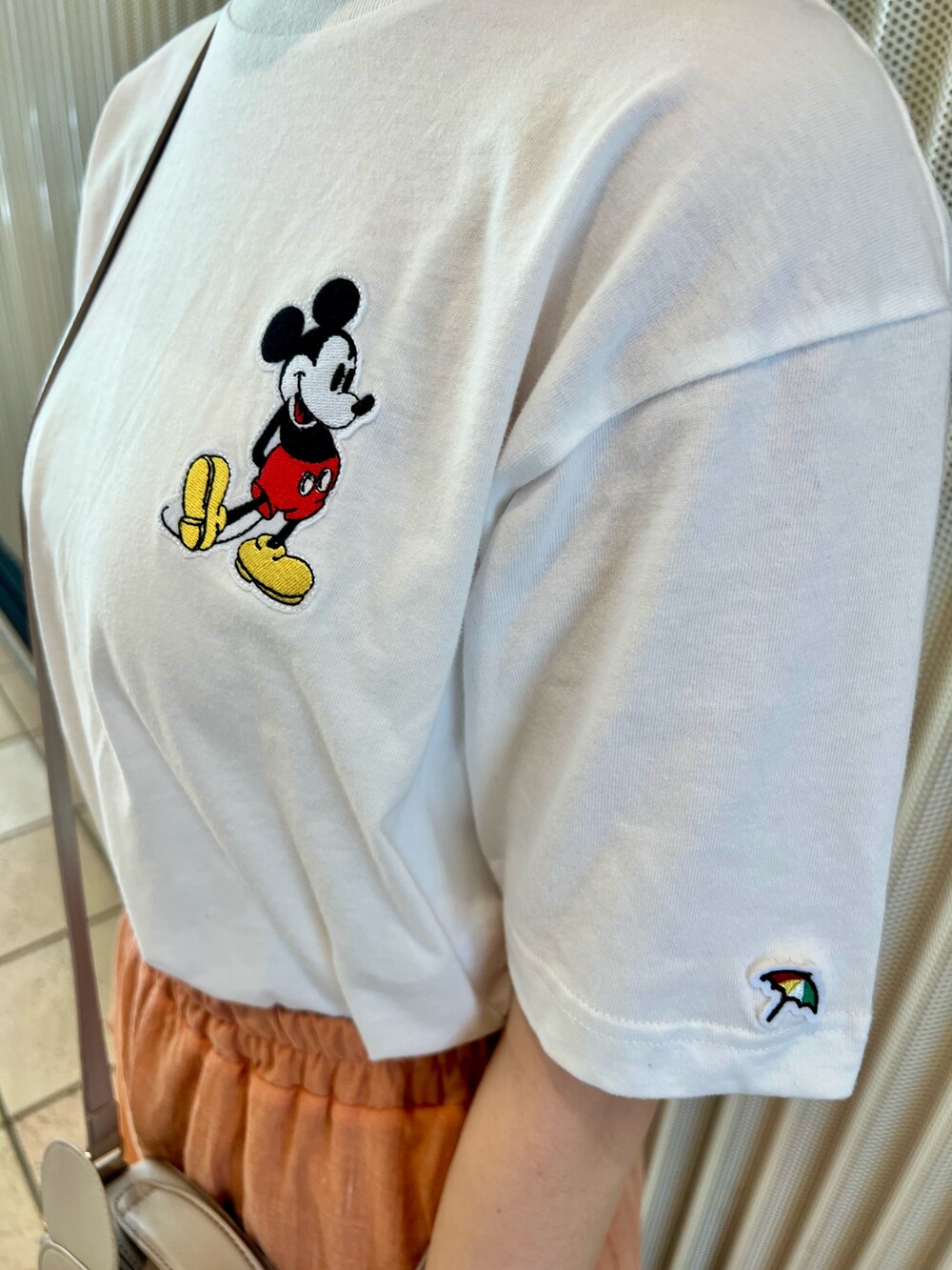 オレンジ系のスカート、ベージュ系のサンダル、ホワイト系のTシャツ/カットソーを着用したレディースの夏コーディネートの5枚目の写真