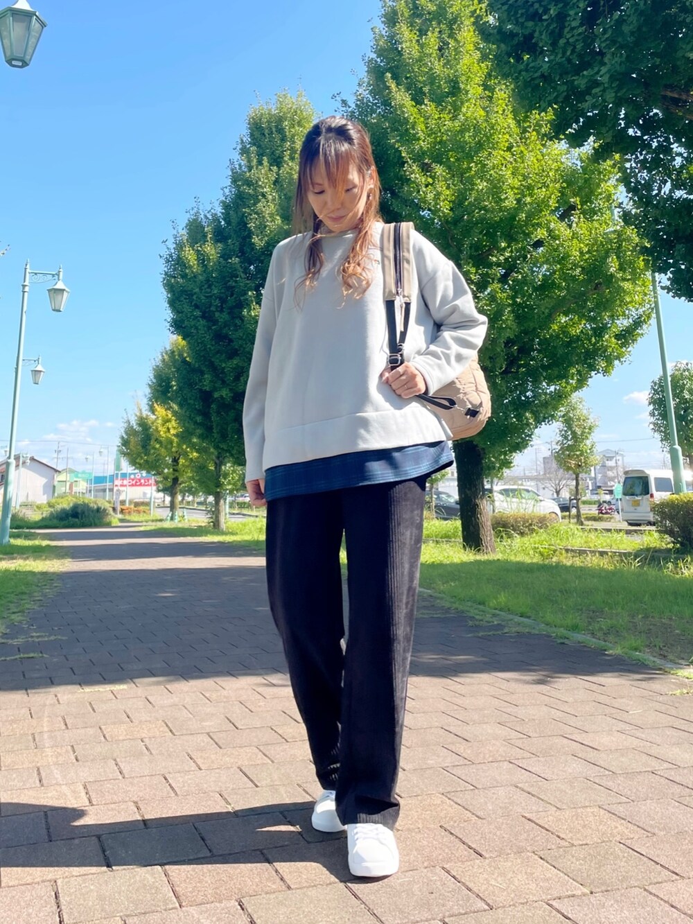 ホワイト系のスニーカー、グレー系のチュニック、ブラック系のその他パンツを着用したレディースの秋コーディネートの2枚目の写真