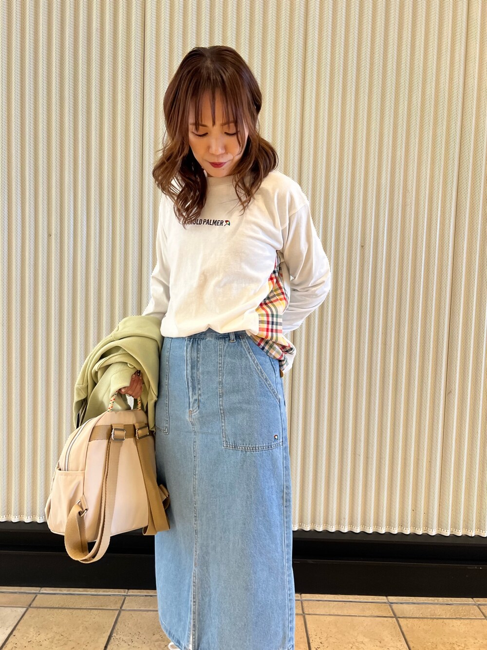 ブルー系のデニムスカート、ホワイト系のTシャツ/カットソー、グリーン系のカーディガン/ボレロを着用したレディースの冬コーディネートの5枚目の写真