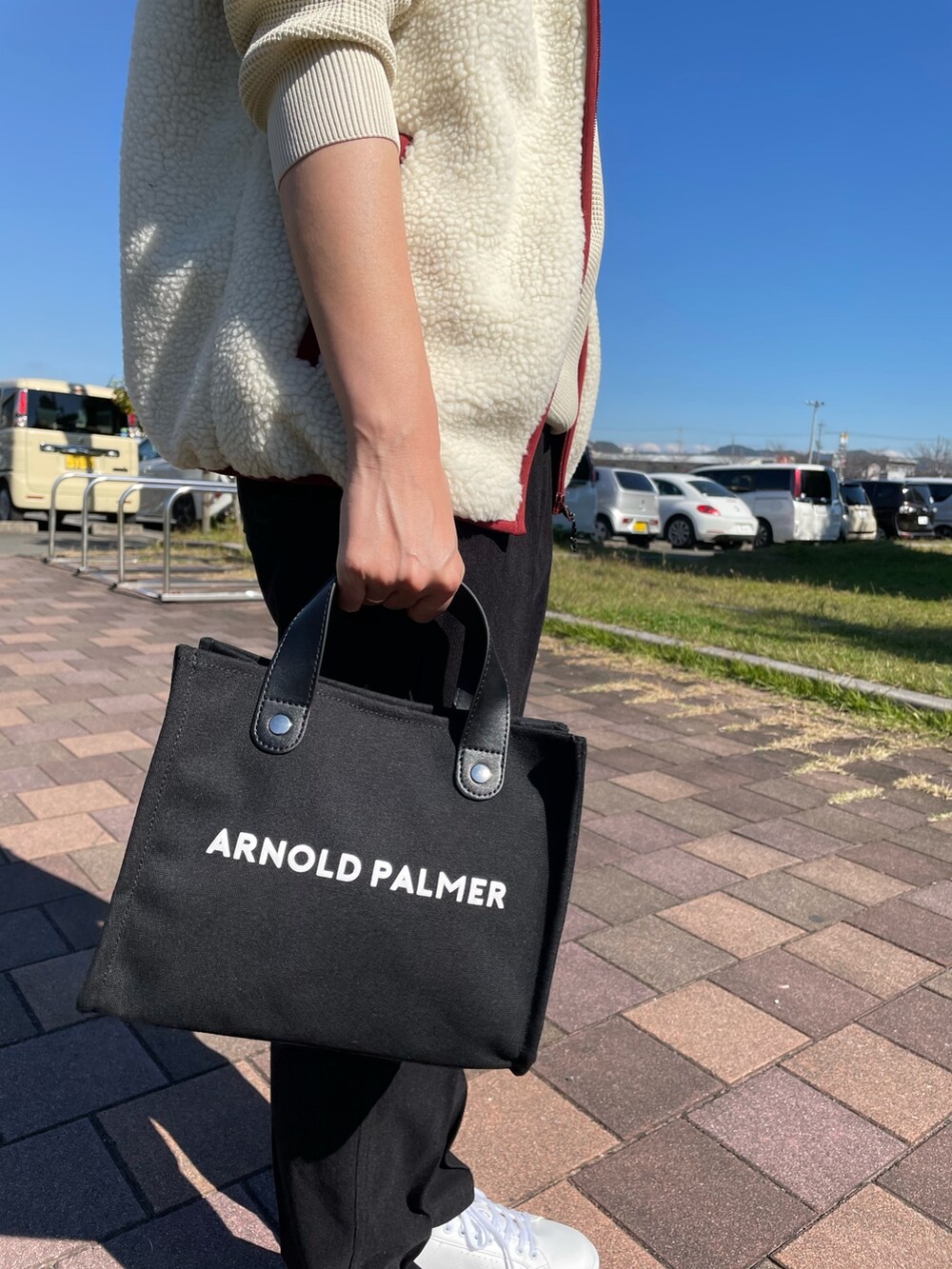 ブラック系のトートバッグ、ブラック系のその他パンツ、ホワイト系のニット/セーターを着用したレディースの秋コーディネートの9枚目の写真