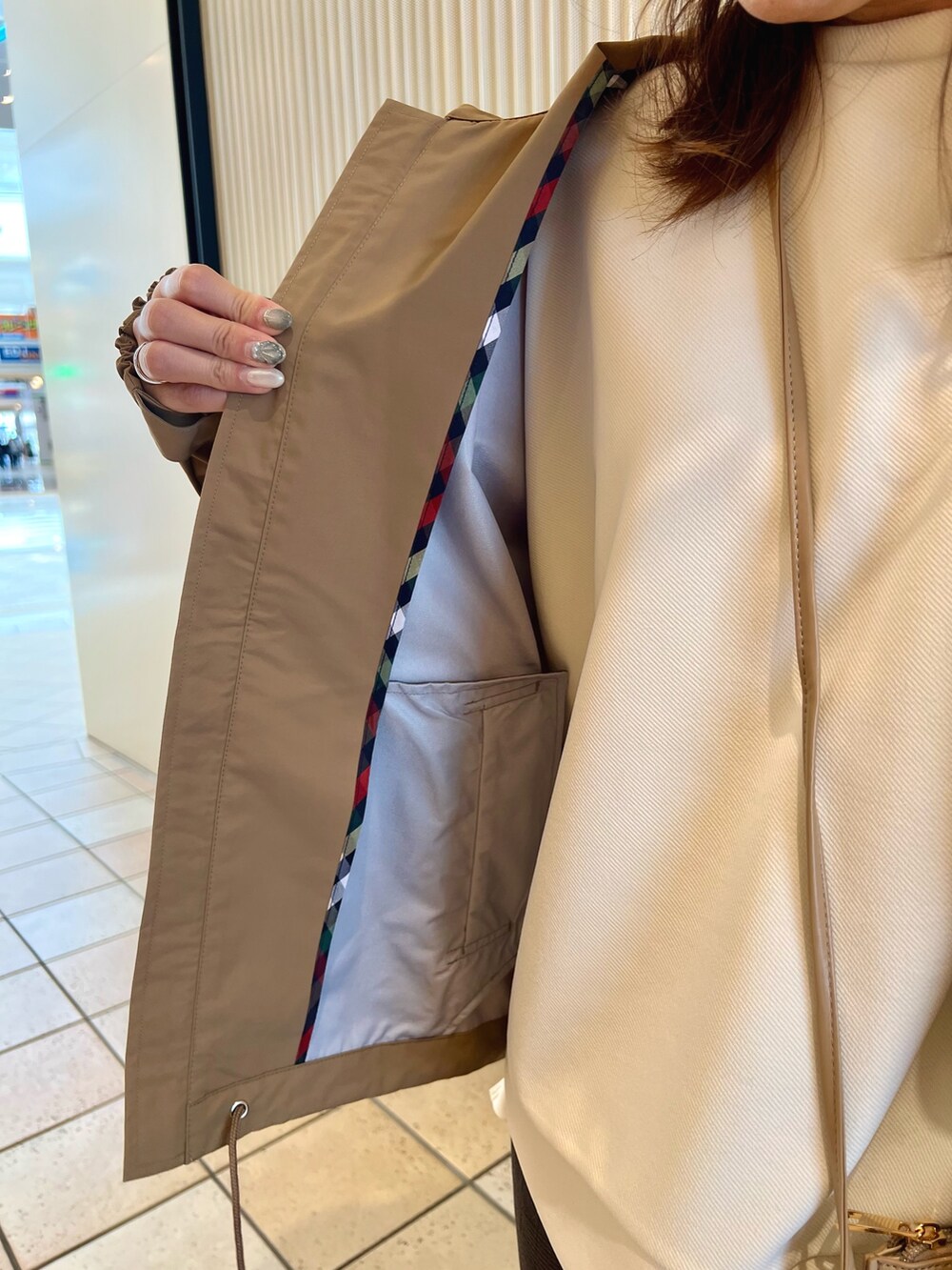 ホワイト系のスウェット、ベージュ系のショルダーバッグ、ベージュ系のブルゾンを着用したレディースの夏コーディネートの7枚目の写真