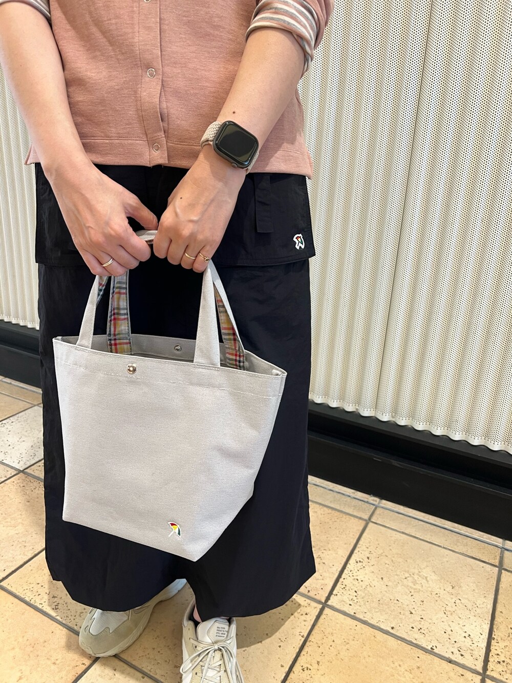 ピンク系のカーディガン/ボレロ、ブラック系のスカート、ベージュ系のトートバッグを着用したレディースの秋コーディネートの6枚目の写真