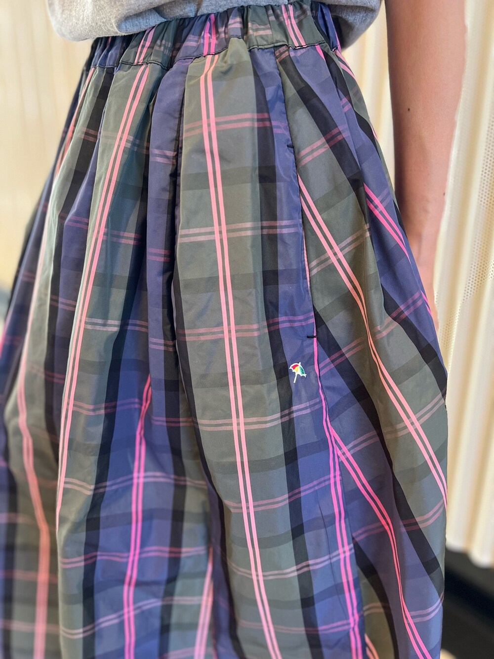 グリーン系のスカート、グレー系のTシャツ/カットソー、ホワイト系のショルダーバッグを着用したレディースの春コーディネートの6枚目の写真