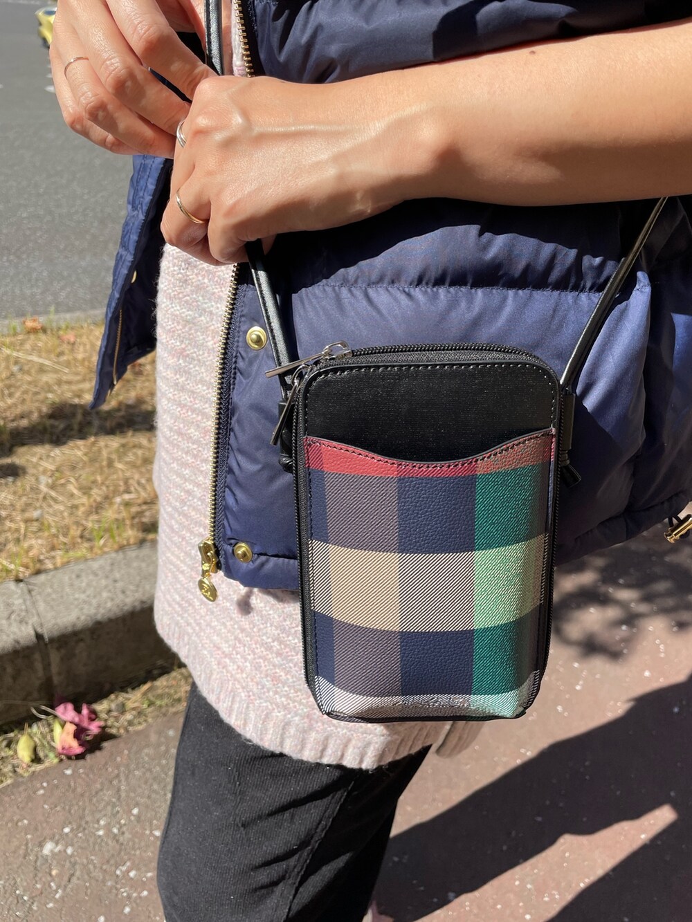 ピンク系のニット/セーター、ブルー系のダウンベスト、ブラック系のショルダーバッグを着用したレディースの秋コーディネートの8枚目の写真