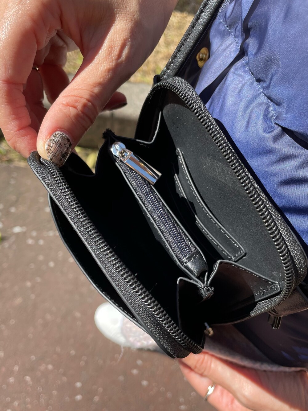 ピンク系のニット/セーター、ブルー系のダウンベスト、ブラック系のショルダーバッグを着用したレディースの秋コーディネートの9枚目の写真