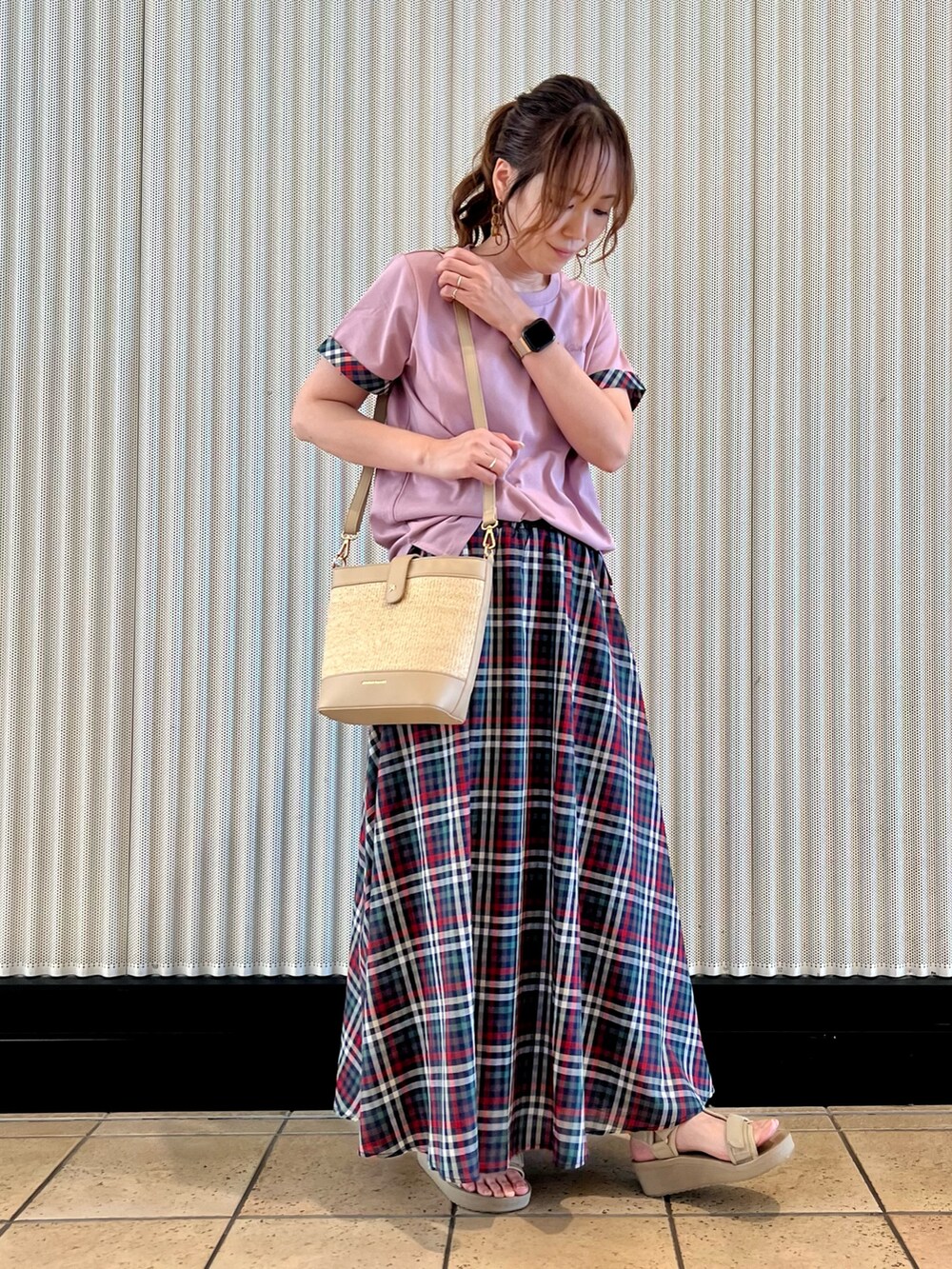 パープル系のTシャツ/カットソー、ブルー系のスカート、ベージュ系のショルダーバッグを着用したレディースの夏コーディネートの3枚目の写真