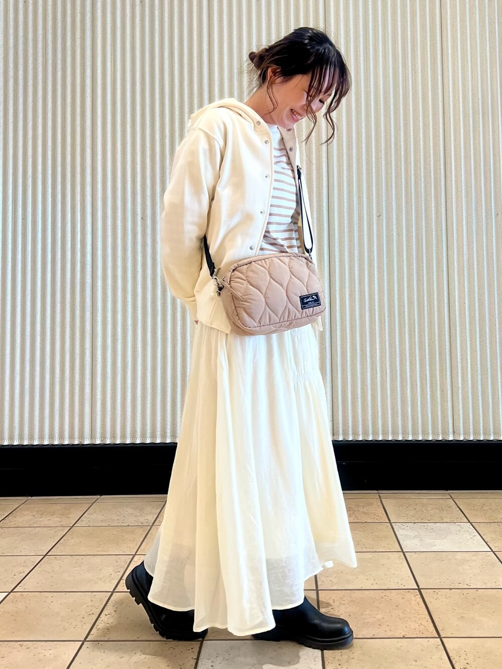 ホワイト系のパーカー、ベージュ系のTシャツ/カットソー、ベージュ系のショルダーバッグを着用したレディースの冬コーディネートの2枚目の写真