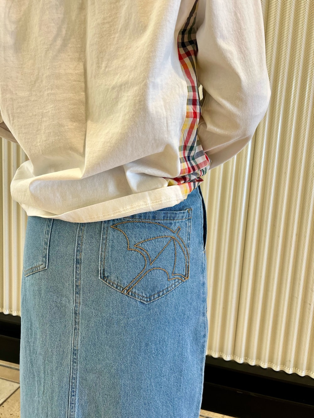 ブルー系のデニムスカート、ホワイト系のTシャツ/カットソー、グリーン系のカーディガン/ボレロを着用したレディースの冬コーディネートの6枚目の写真