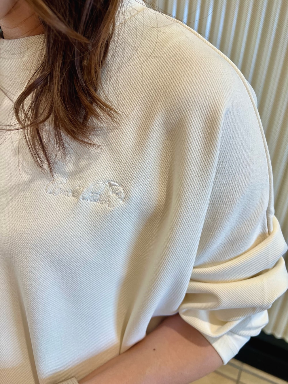 ホワイト系のスウェット、ベージュ系のショルダーバッグ、ベージュ系のブルゾンを着用したレディースの夏コーディネートの6枚目の写真