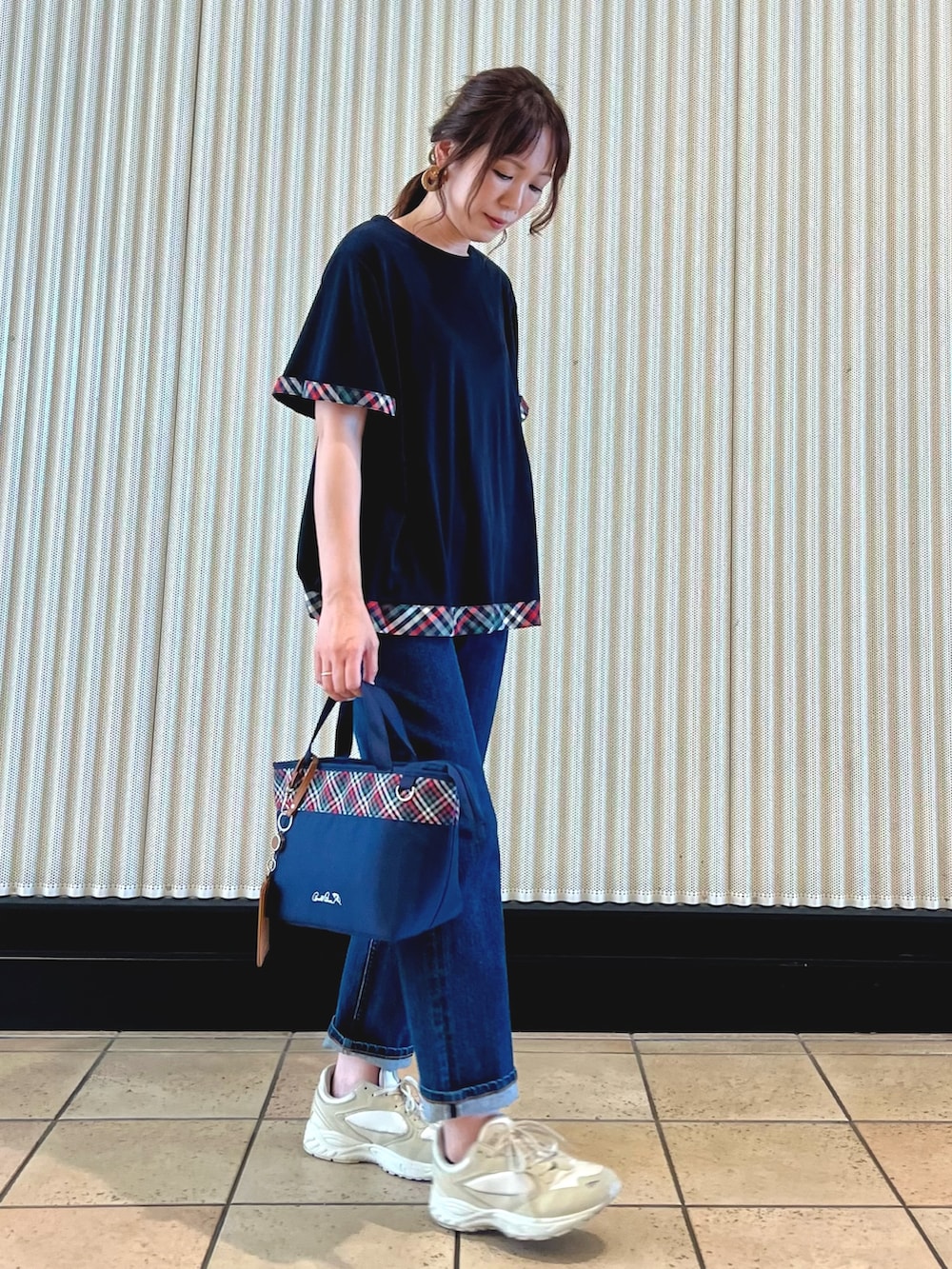 ブルー系のチュニック、ブルー系のトートバッグ、ブルー系のデニムパンツを着用したレディースの夏コーディネートの5枚目の写真