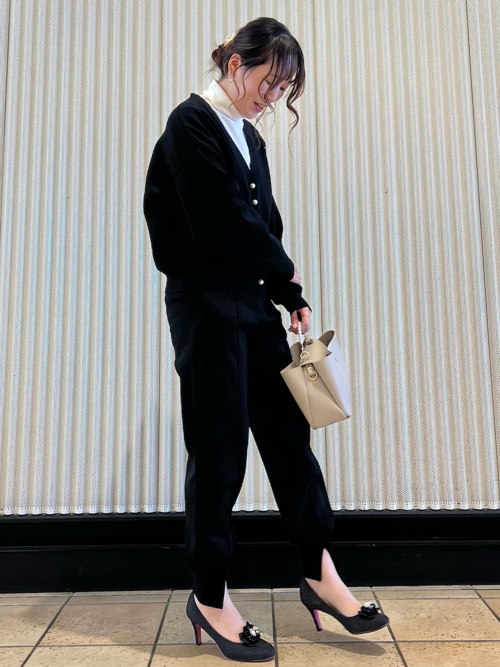 ブラック系のカーディガン/ボレロ、ベージュ系のバッグ、ブラック系のその他パンツを着用したレディースの冬コーディネートの2枚目の写真