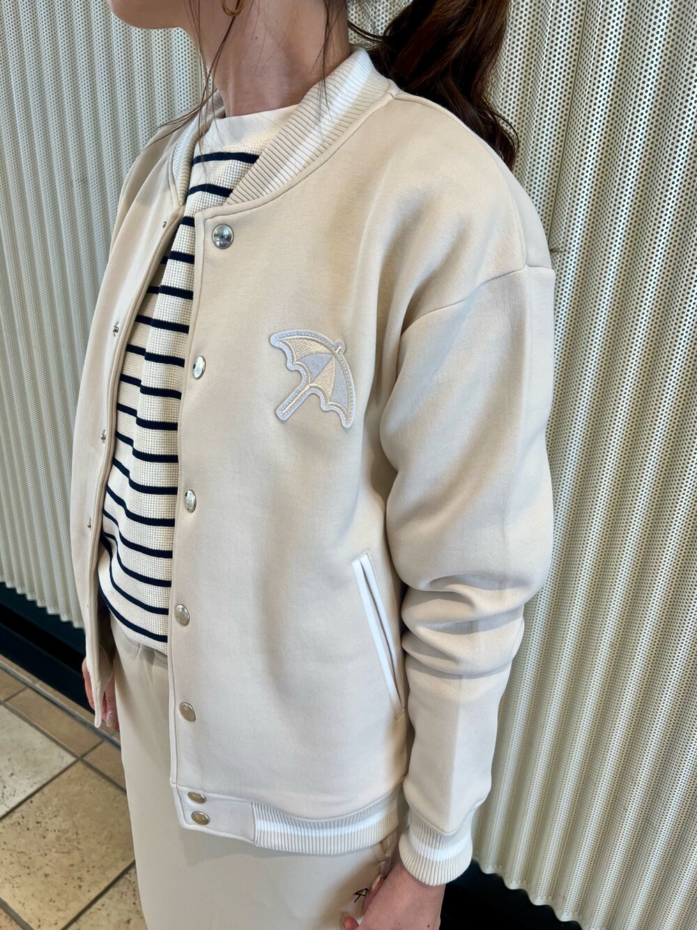 ホワイト系のスタジャン、ベージュ系のTシャツ/カットソー、ホワイト系のスカートを着用したレディースの秋コーディネートの4枚目の写真