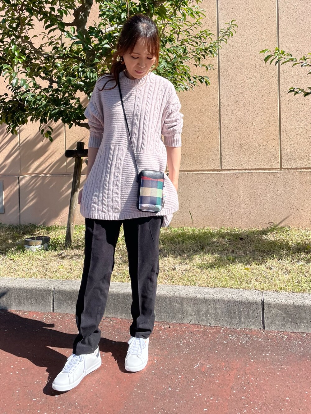 ピンク系のニット/セーター、ブルー系のダウンベスト、ブラック系のショルダーバッグを着用したレディースの秋コーディネートの7枚目の写真