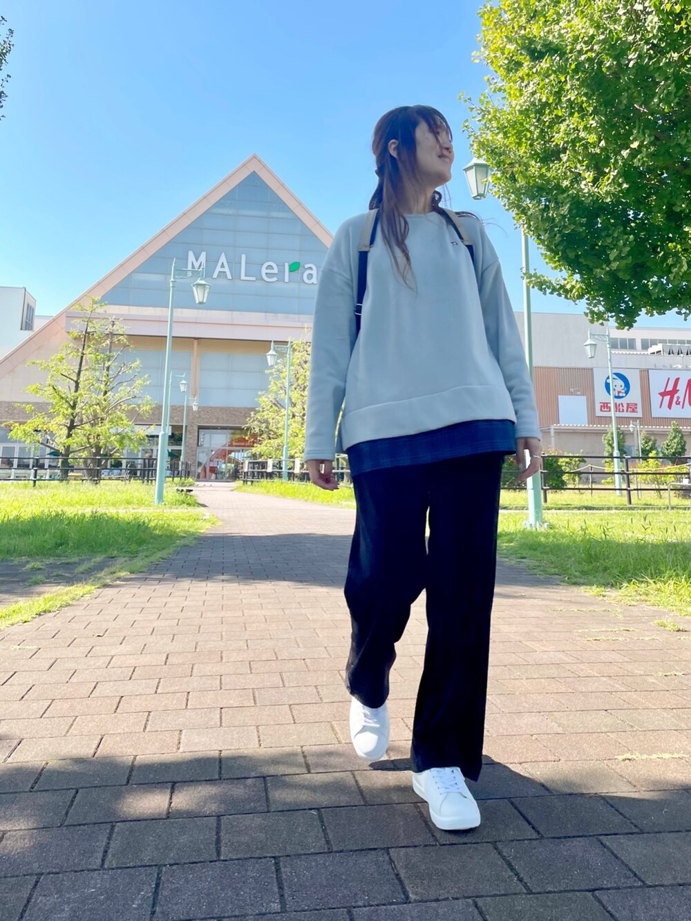 ホワイト系のスニーカー、グレー系のチュニック、ブラック系のその他パンツを着用したレディースの秋コーディネートの4枚目の写真