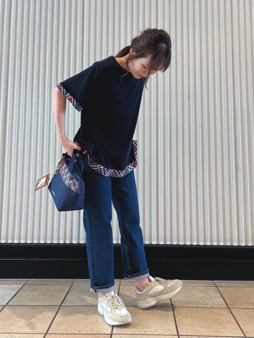 ブルー系のチュニック、ブルー系のトートバッグ、ブルー系のデニムパンツを着用したレディースの夏コーディネートの6枚目の写真