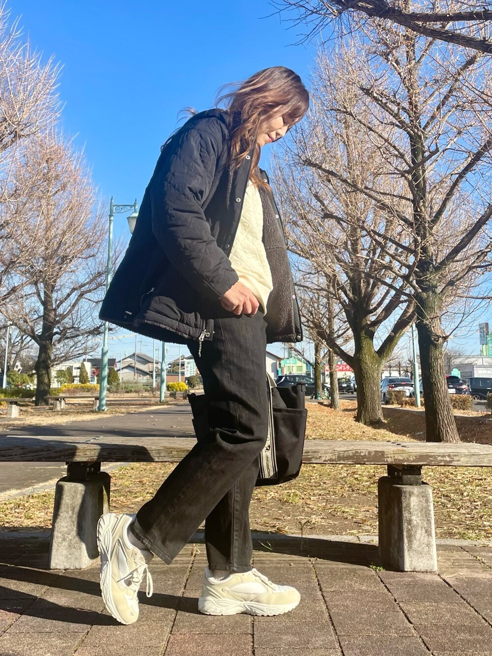 ブラック系のその他アウター、ホワイト系のTシャツ/カットソー、ブラック系のトートバッグを着用したレディースの冬コーディネートの3枚目の写真