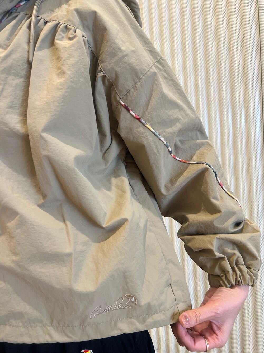 ベージュ系のナイロンジャケット、ホワイト系のTシャツ/カットソー、ブラック系のスカートを着用したレディースの春コーディネートの5枚目の写真