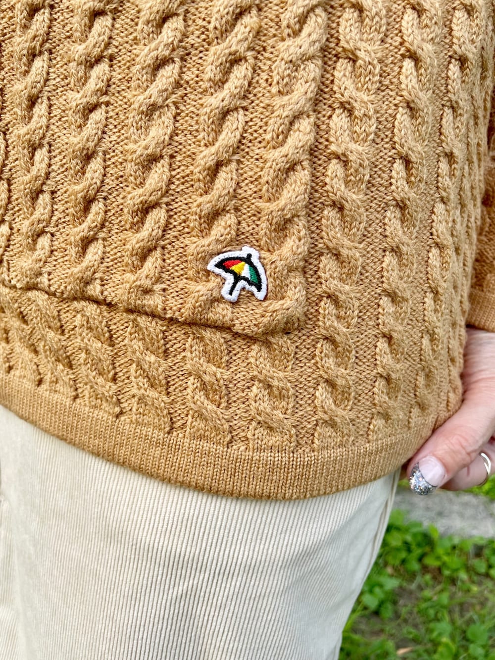 ブラウン系のショルダーバッグ、イエロー系のカーディガン/ボレロ、ホワイト系のスニーカーを着用したレディースの秋コーディネートの5枚目の写真