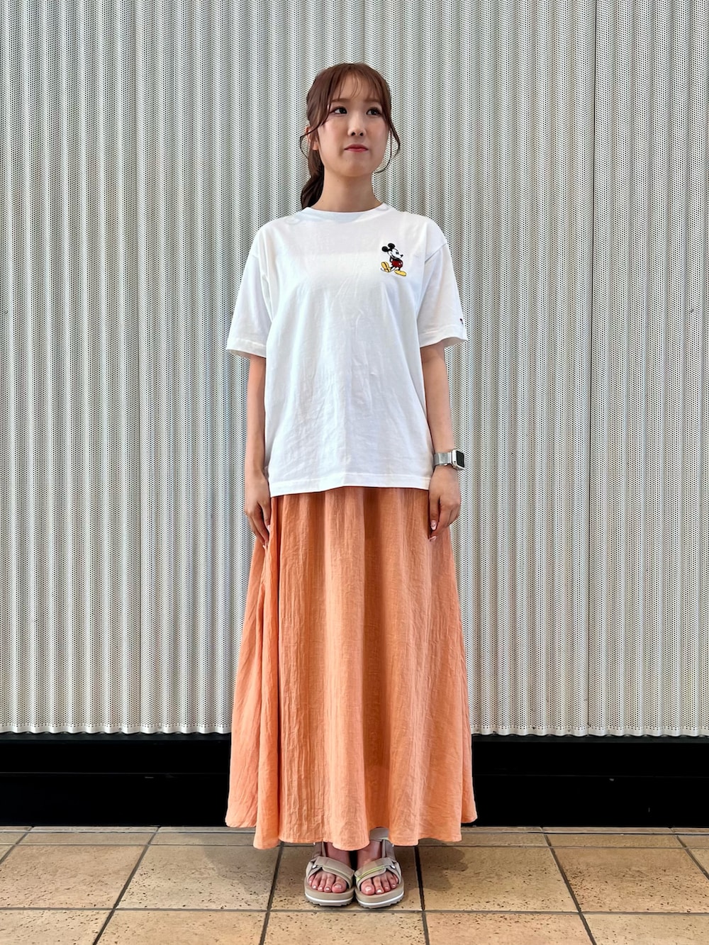 オレンジ系のスカート、ベージュ系のサンダル、ホワイト系のTシャツ/カットソーを着用したレディースの夏コーディネートの9枚目の写真