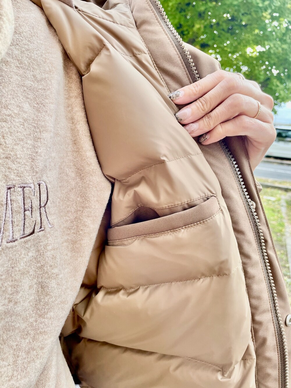 ベージュ系のスカート、ベージュ系のパーカー、ベージュ系のダウンジャケット/コートを着用したレディースの秋コーディネートの6枚目の写真