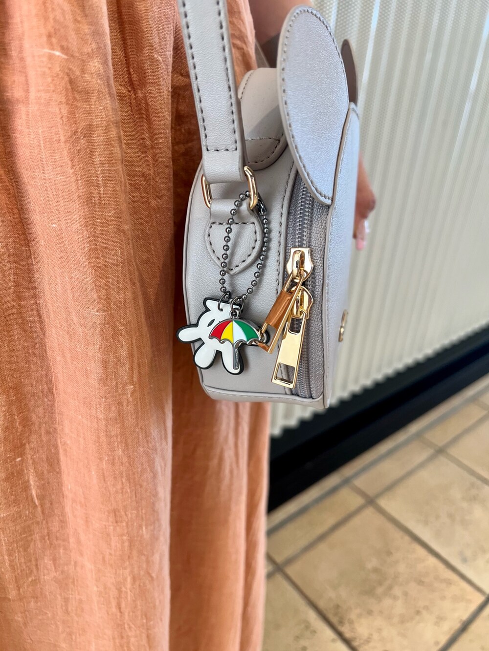 オレンジ系のスカート、ベージュ系のサンダル、ホワイト系のTシャツ/カットソーを着用したレディースの夏コーディネートの7枚目の写真