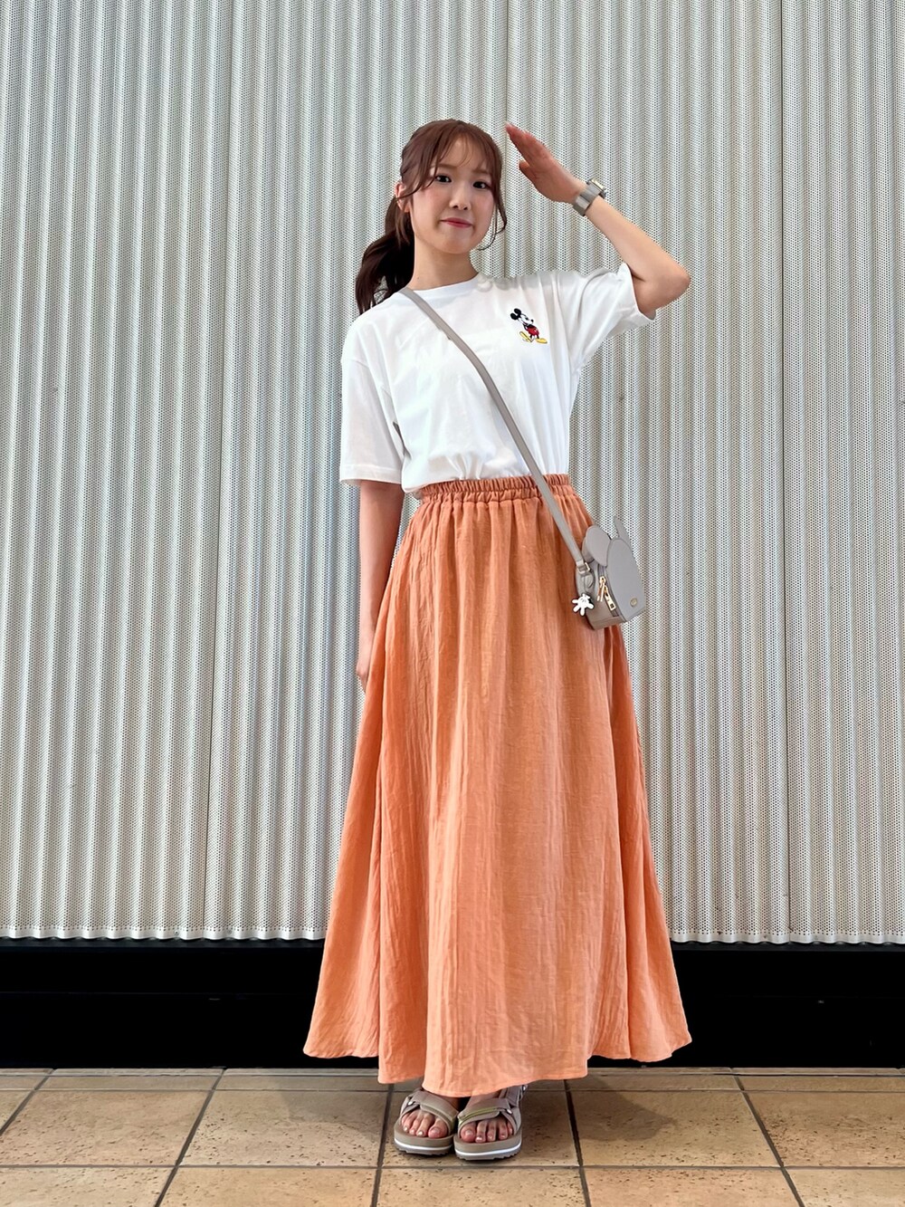 オレンジ系のスカート、ベージュ系のサンダル、ホワイト系のTシャツ/カットソーを着用したレディースの夏コーディネートの4枚目の写真