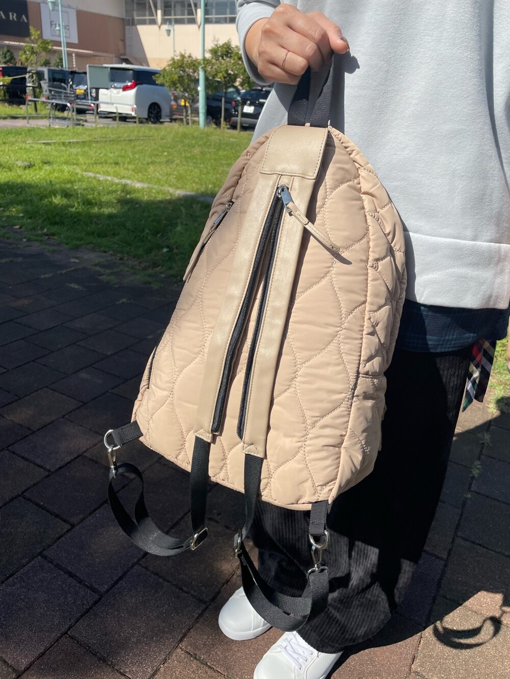 ホワイト系のスニーカー、グレー系のチュニック、ブラック系のその他パンツを着用したレディースの秋コーディネートの6枚目の写真
