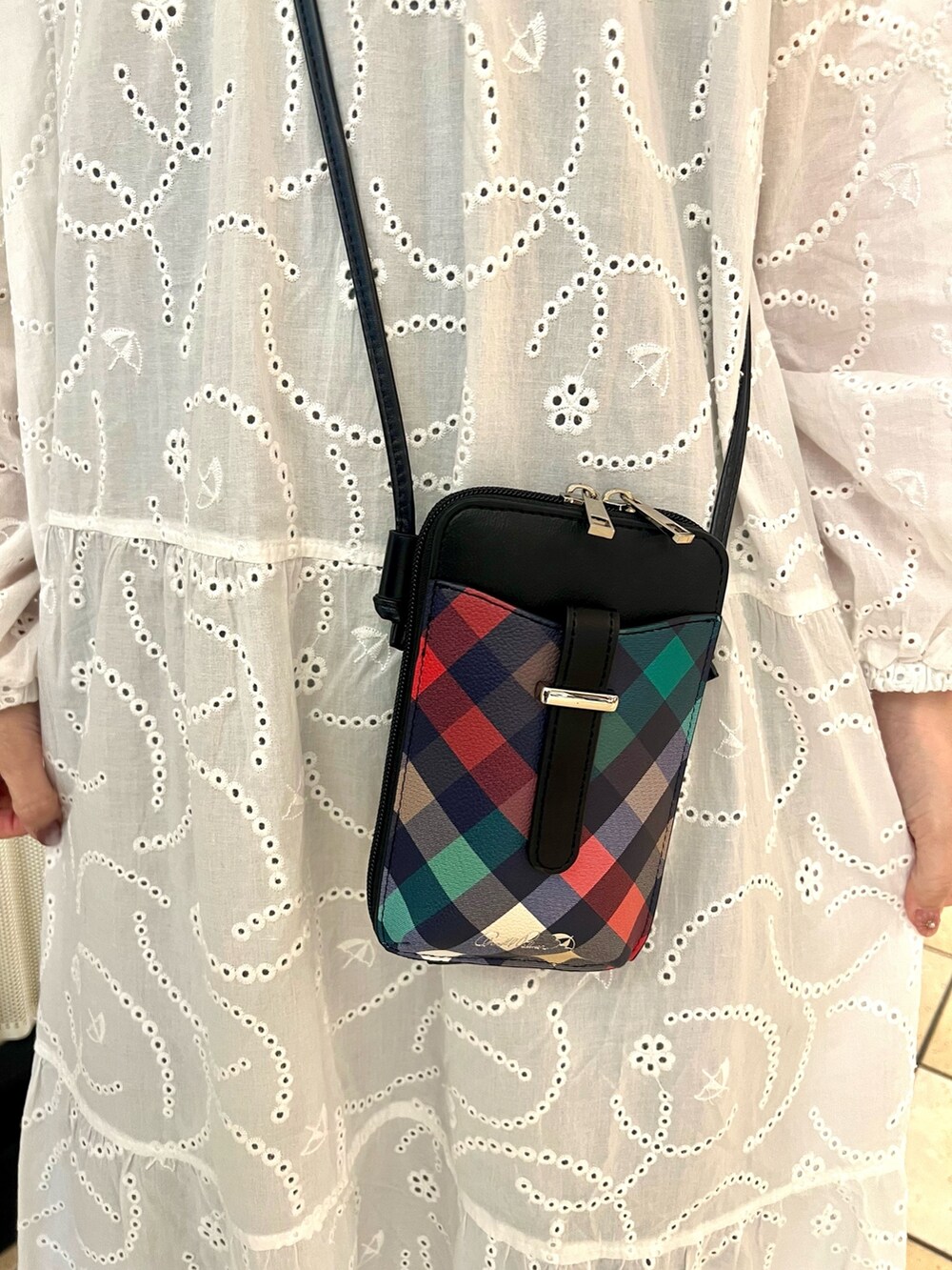 ブラック系のショルダーバッグ、ブラック系のスニーカー、ブルー系のデニムジャケットを着用したレディースの春コーディネートの7枚目の写真