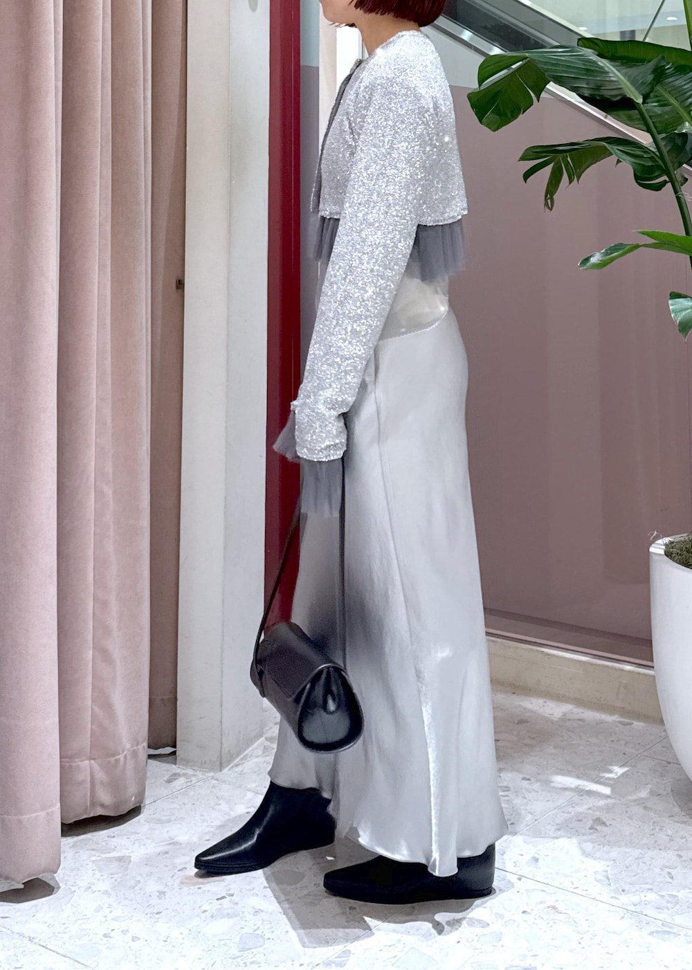 ブラック系のショルダーバッグ、ブラック系のブーツ、グレー系のカーディガン/ボレロを着用したレディースの冬コーディネートの7枚目の写真