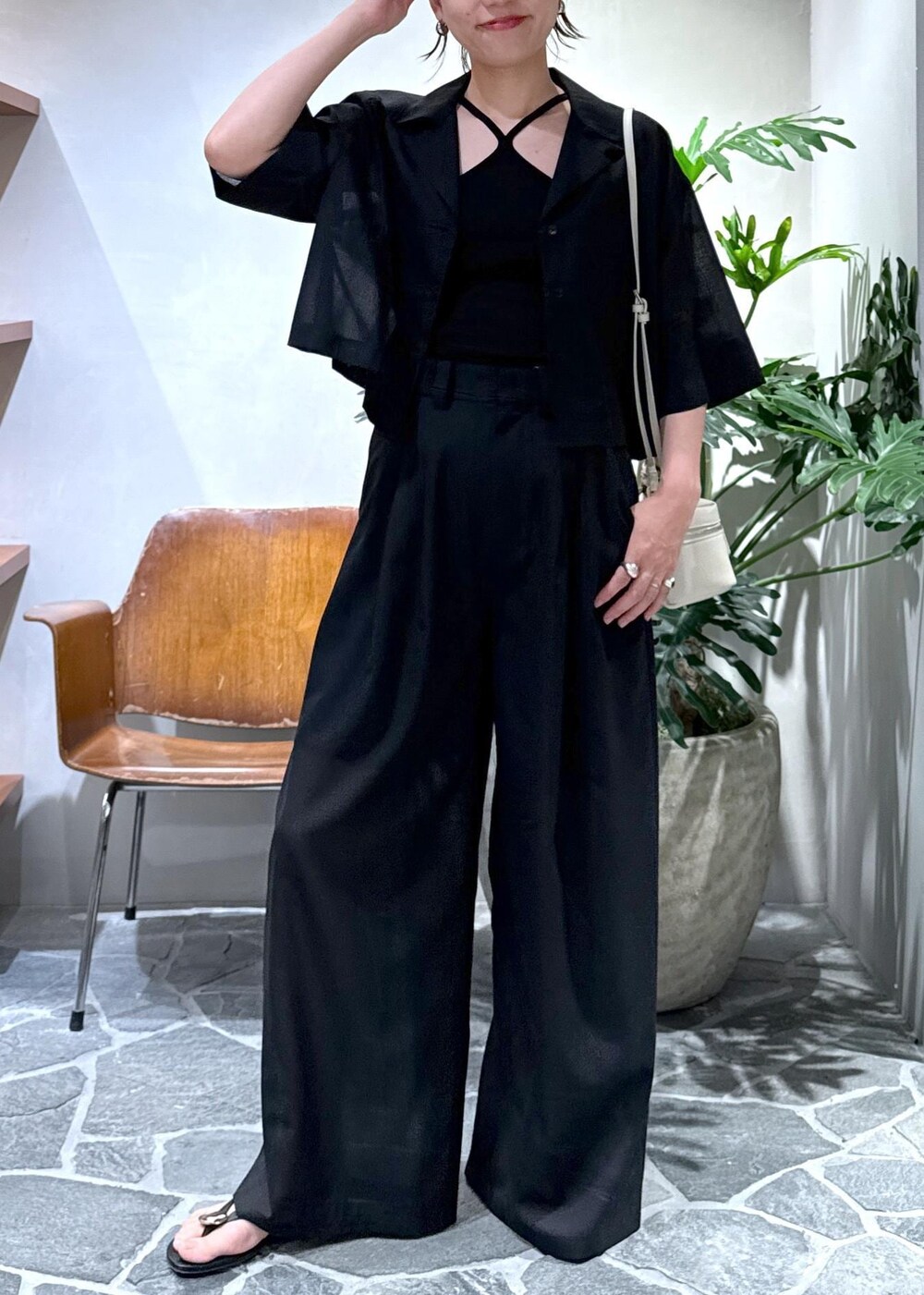 ホワイト系のショルダーバッグ、ブラック系のキャミソール、ブラック系のスラックスを着用したレディースの夏コーディネートの9枚目の写真