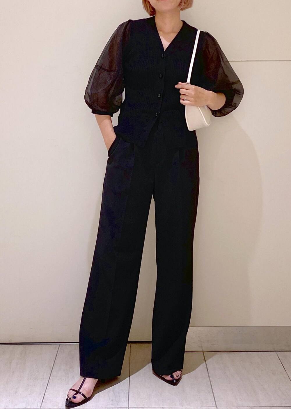 ブラック系のサンダル、ホワイト系のショルダーバッグ、ブラック系のスラックスを着用したレディースの夏コーディネートの4枚目の写真