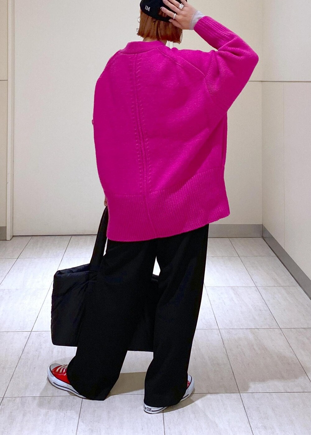 ピンク系のカーディガン/ボレロ、ブラック系のトートバッグ、ブラック系のキャップを着用したレディースの冬コーディネートの5枚目の写真