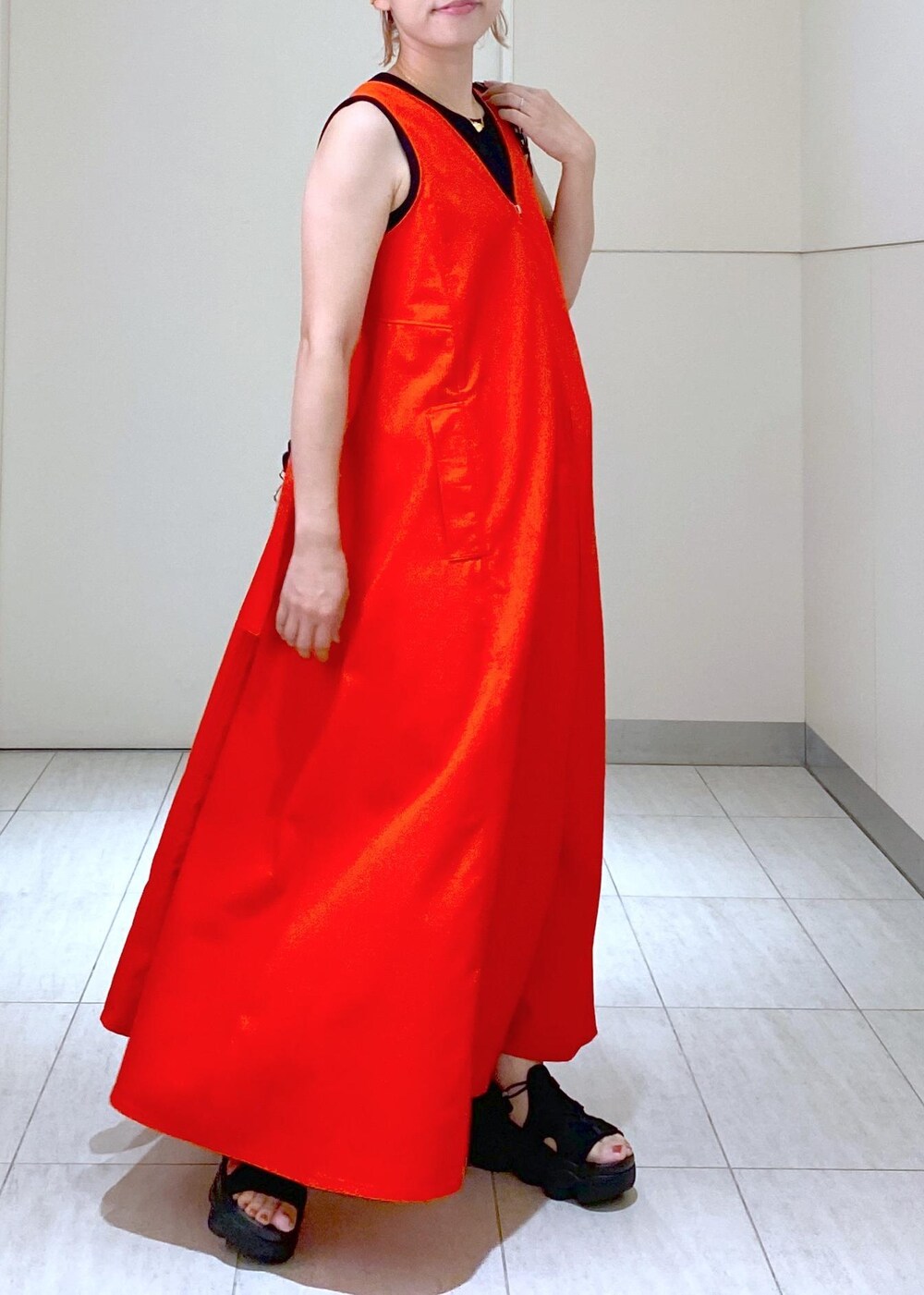 ブラック系のサンダル、ブラック系のドラムバッグ、レッド系のワンピースを着用したレディースの夏コーディネートの6枚目の写真