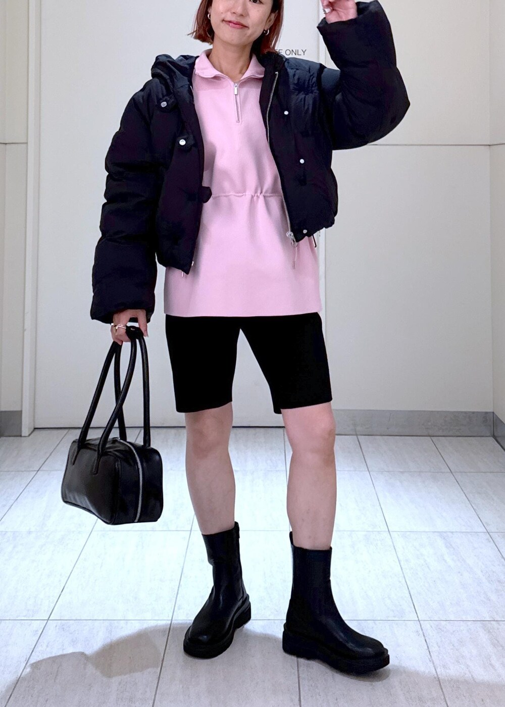 ブラック系のブーツ、ピンク系のその他トップス、ブラック系のボストンバッグを着用したレディースの秋コーディネートの4枚目の写真