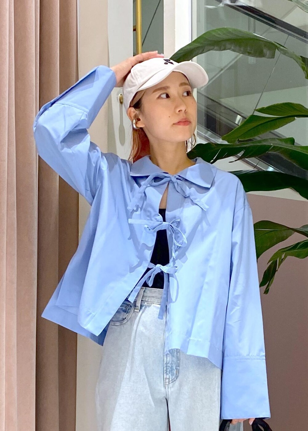 ブルー系のデニムパンツ、ブラック系のトートバッグ、ベージュ系のサンダルを着用したレディースの秋コーディネートの8枚目の写真