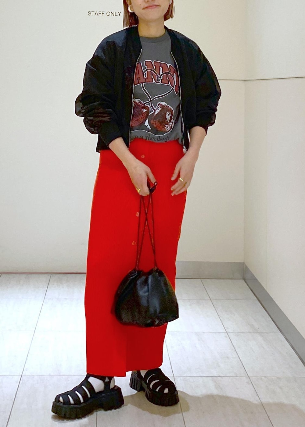 ブラック系のサンダル、ブラック系のショルダーバッグ、レッド系のスカートを着用したレディースの春コーディネートの2枚目の写真