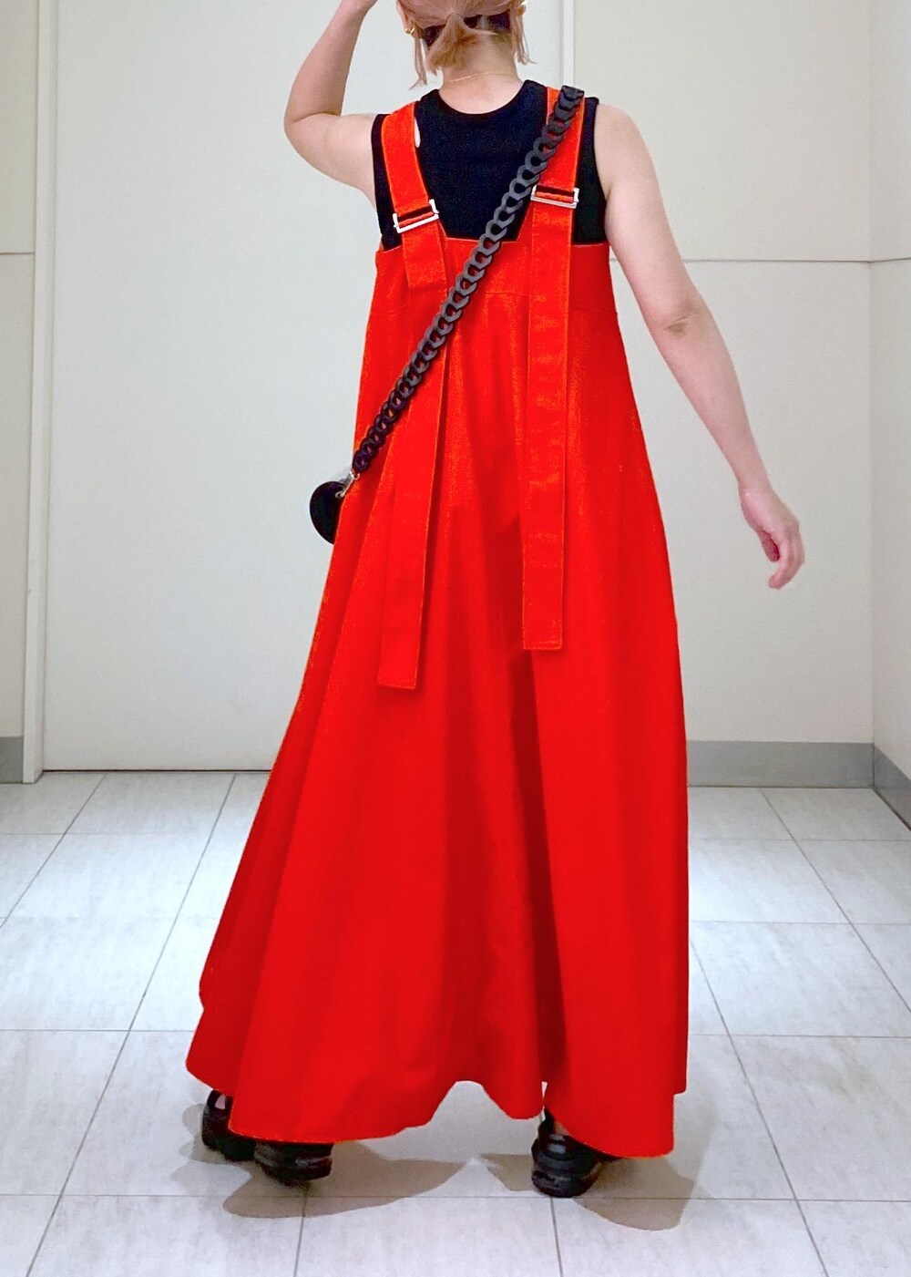 ブラック系のサンダル、ブラック系のドラムバッグ、レッド系のワンピースを着用したレディースの夏コーディネートの9枚目の写真