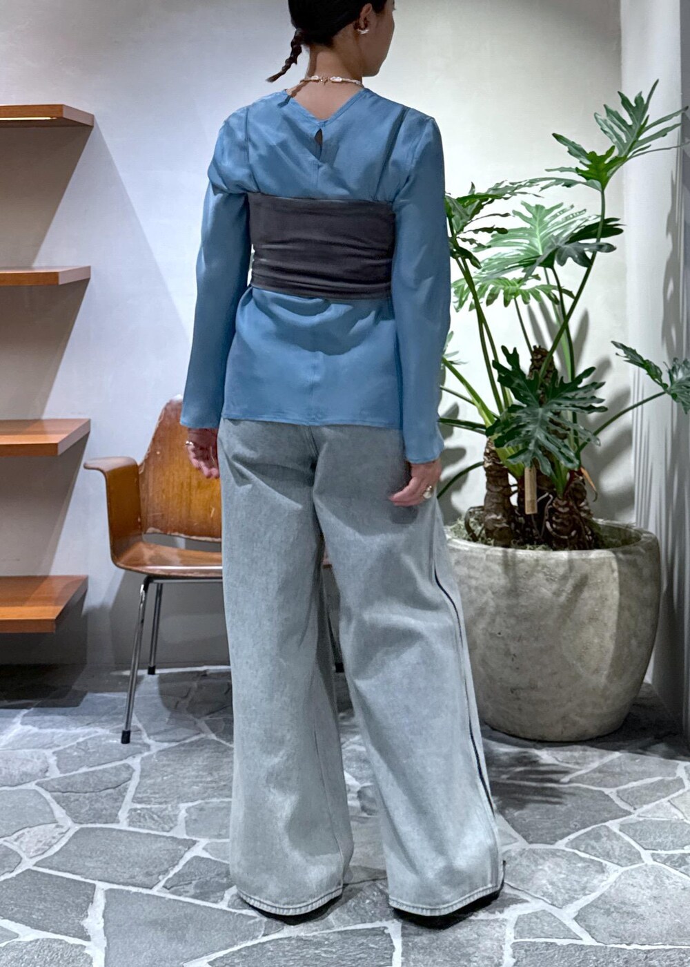 ブラック系のサンダル、ブラウン系のキャミソール、ブルー系のデニムパンツを着用したレディースの秋コーディネートの6枚目の写真