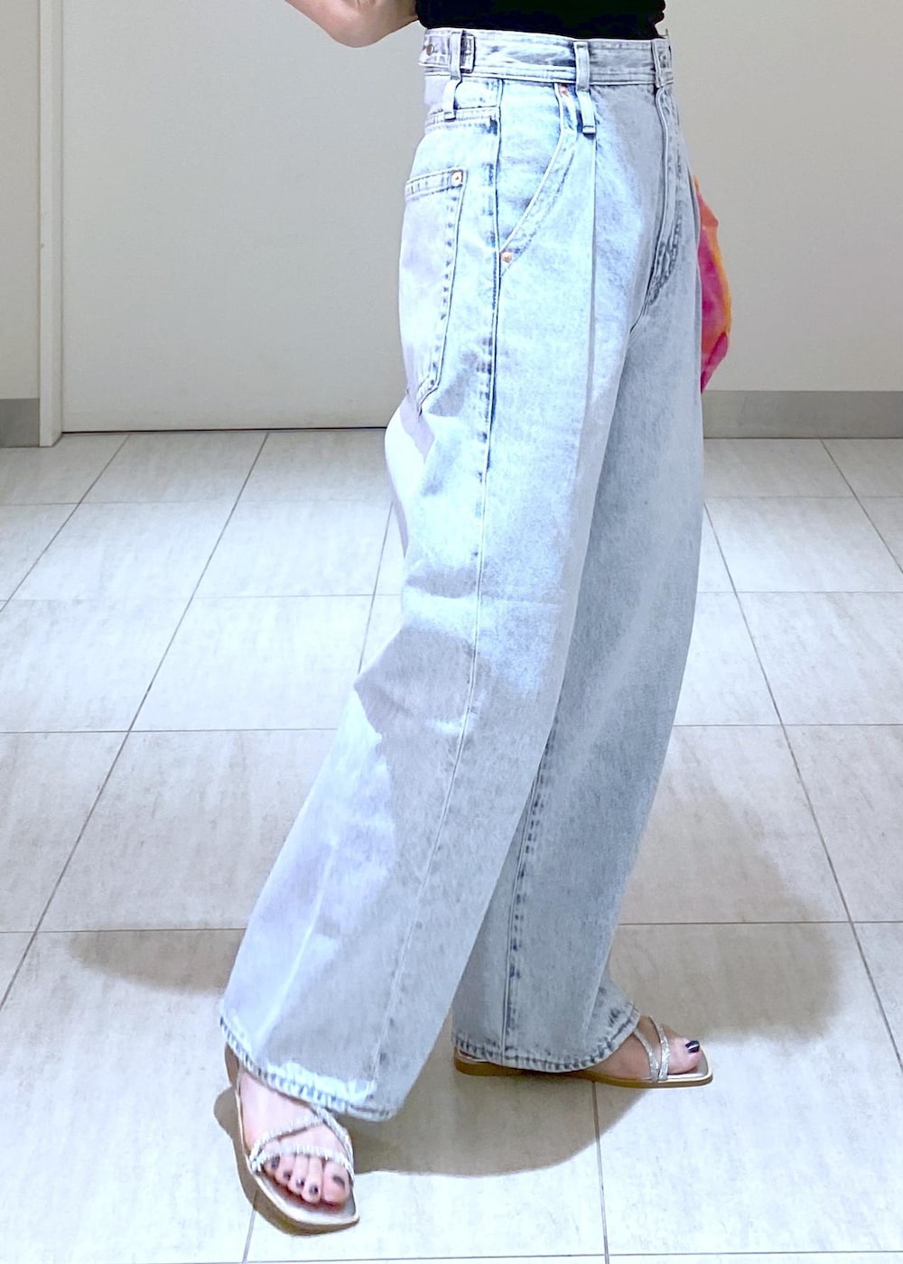 シルバー系のサンダル、ブラック系のニット/セーター、ブルー系のデニムパンツを着用したレディースの春コーディネートの9枚目の写真