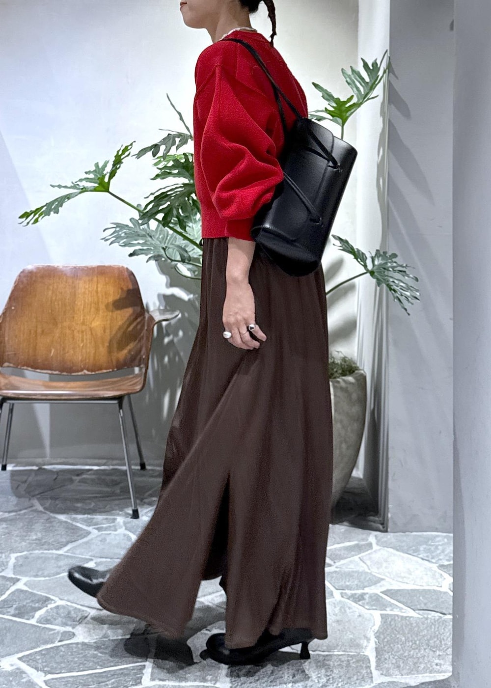 ブラック系のブーツ、ブラウン系のスカート、レッド系のニット/セーターを着用したレディースの秋コーディネートの3枚目の写真