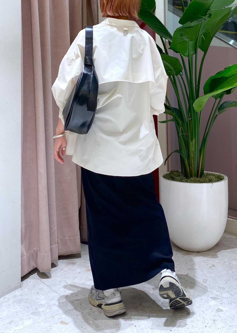 ブラック系のショルダーバッグ、ブラック系のワンピース、ホワイト系のシャツ/ブラウスを着用したレディースの春コーディネートの5枚目の写真