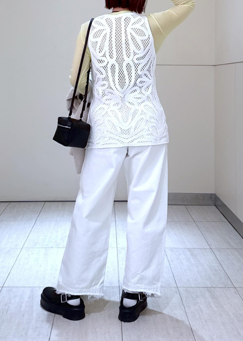 ホワイト系のデニムパンツ、ブラック系のショルダーバッグ、グリーン系のTシャツ/カットソーを着用したレディースの冬コーディネートの9枚目の写真