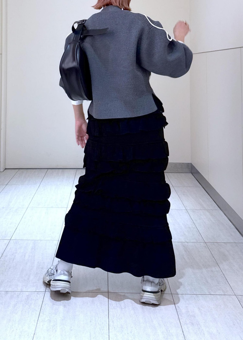 ホワイト系のTシャツ/カットソー、ブラック系のスカート、グレー系のカーディガン/ボレロを着用したレディースの秋コーディネートの6枚目の写真