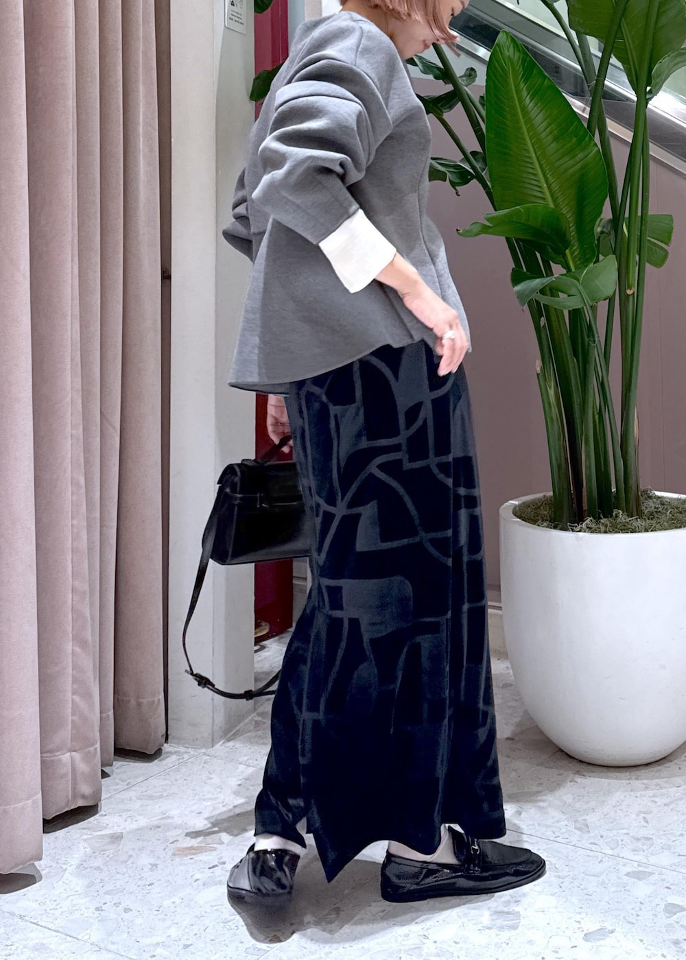 ブラック系のローファー、ブラック系のスカート、グレー系のカーディガン/ボレロを着用したレディースの秋コーディネートの5枚目の写真