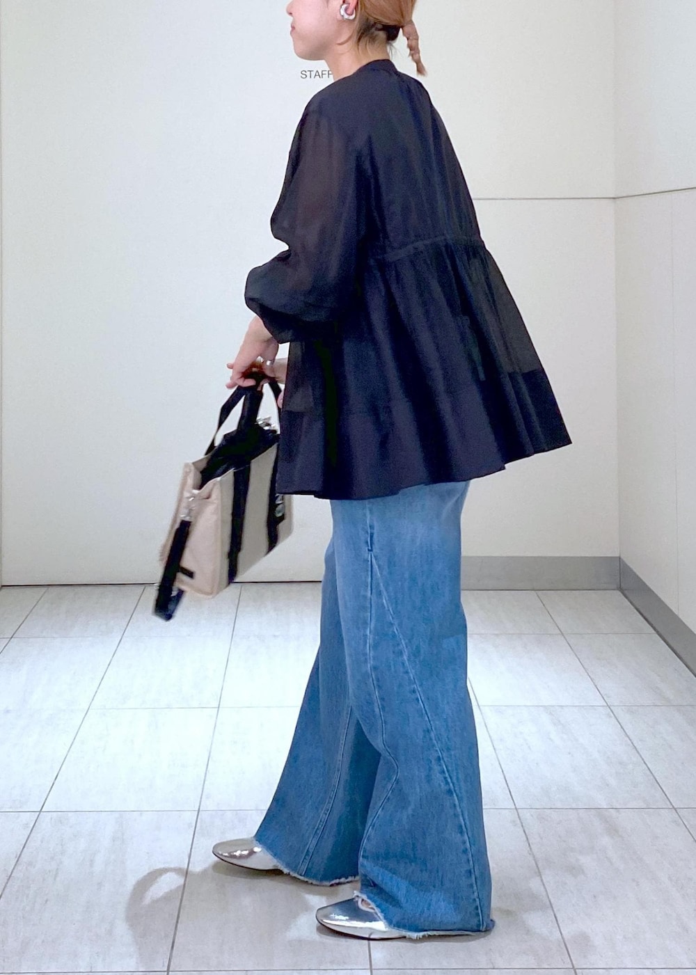 ブルー系のデニムパンツ、シルバー系のバレエシューズ、ブラック系のTシャツ/カットソーを着用したレディースの夏コーディネートの4枚目の写真