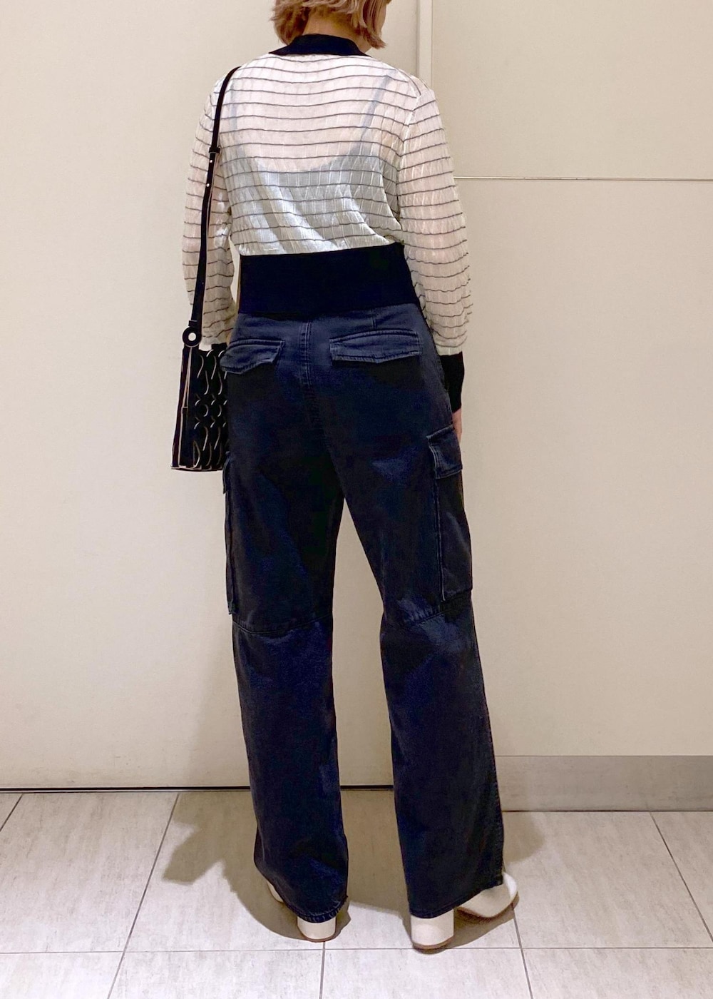 ホワイト系のその他シューズ、ブラック系のカーゴパンツ、ホワイト系のカーディガン/ボレロを着用したレディースの夏コーディネートの4枚目の写真