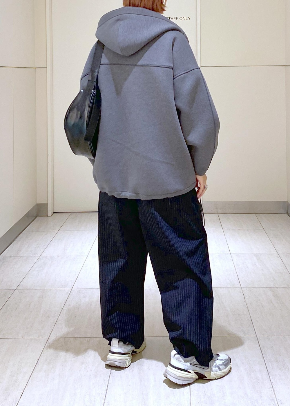 ブルー系のニット/セーター、グレー系のブルゾン、ブラック系のショルダーバッグを着用したレディースの冬コーディネートの3枚目の写真