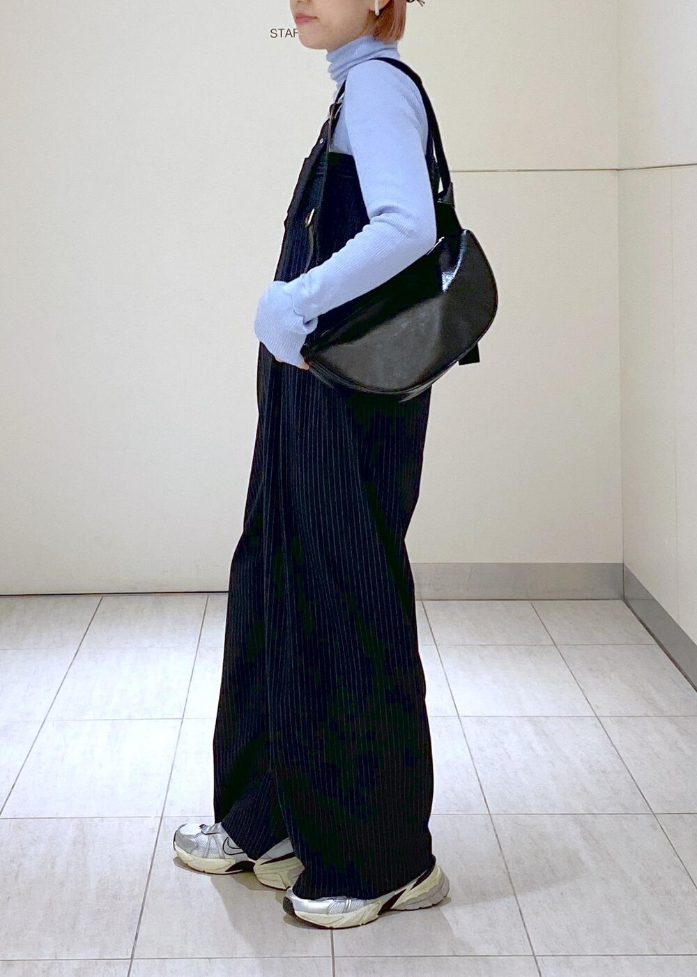 ブルー系のニット/セーター、グレー系のブルゾン、ブラック系のショルダーバッグを着用したレディースの冬コーディネートの6枚目の写真