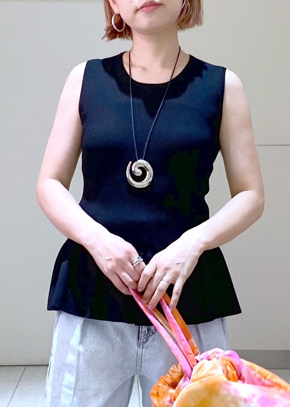 シルバー系のサンダル、ブラック系のニット/セーター、ブルー系のデニムパンツを着用したレディースの春コーディネートの6枚目の写真